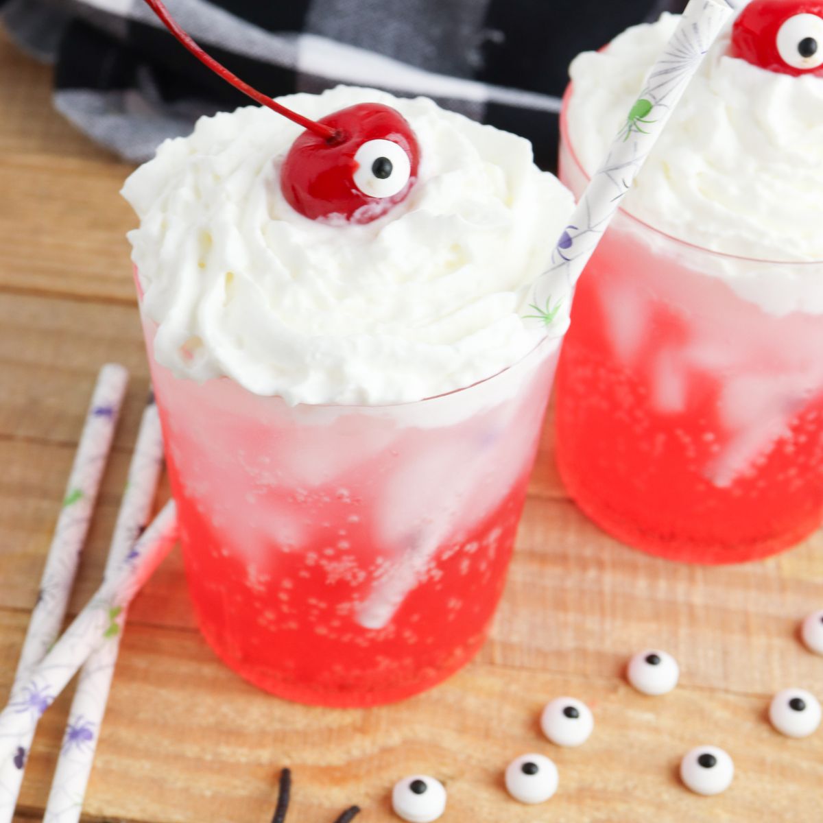 Two glasses with whipped cream and eyeballs on top.