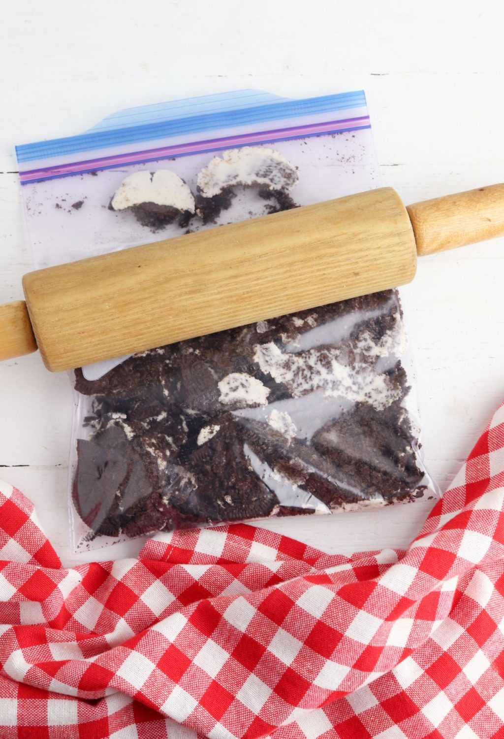 A rolling pin next to a bag of cookie dough.