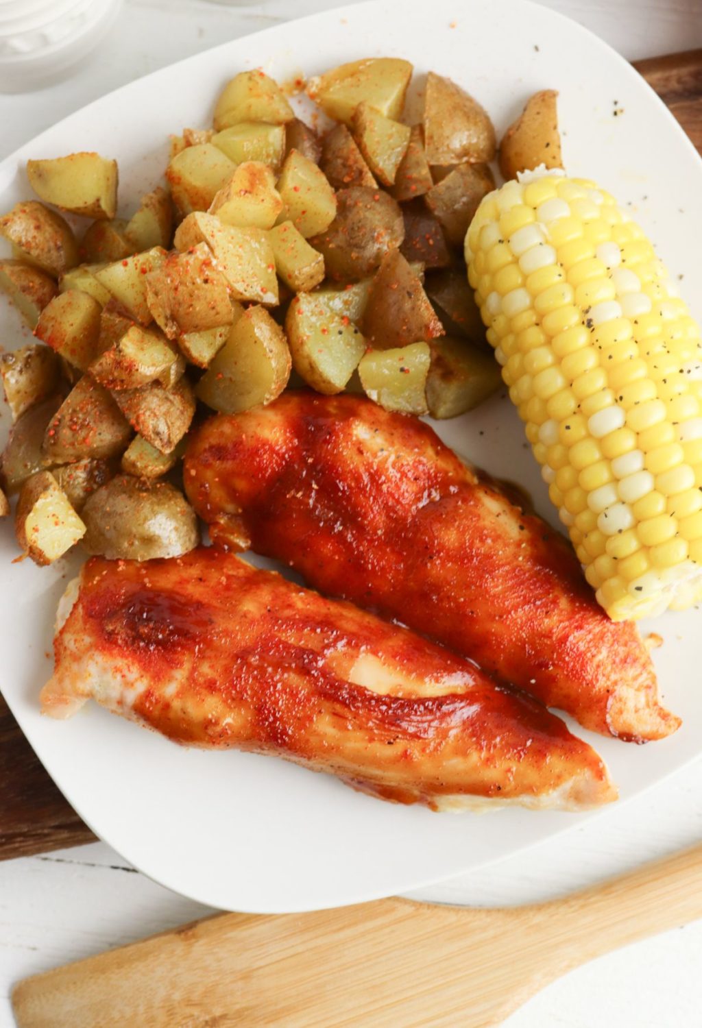 A plate with chicken, potatoes and corn.