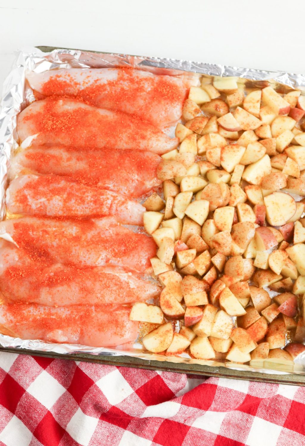 A baking sheet with salmon and potatoes on it.