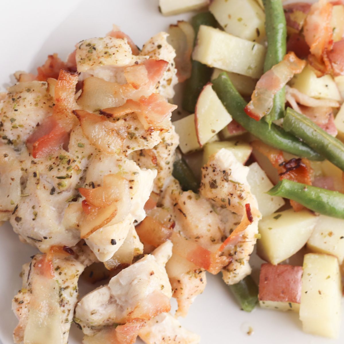 A plate with chicken, green beans and potatoes.