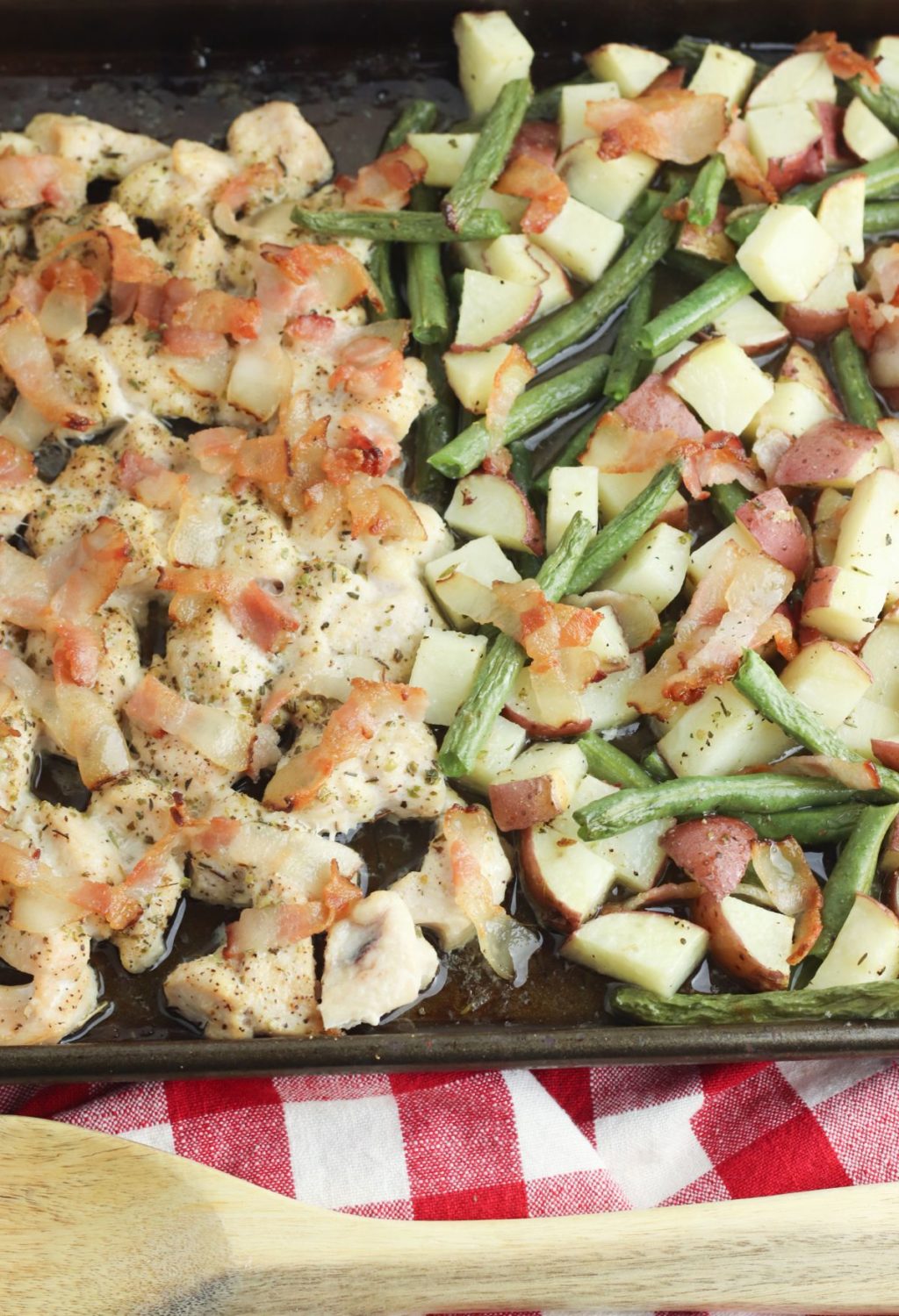 Chicken and green beans on a baking sheet.