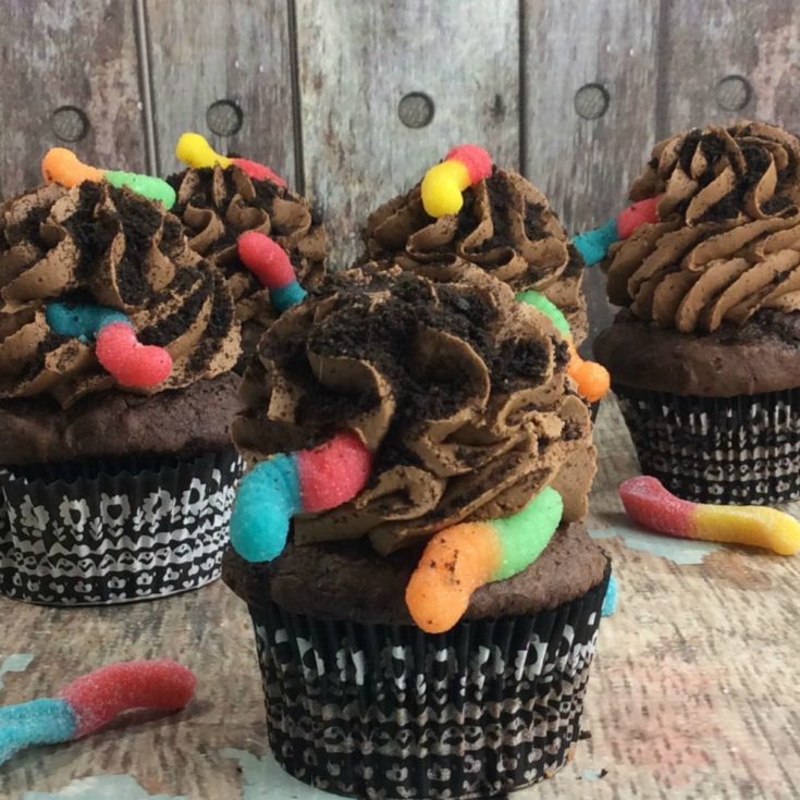 Oreo cupcakes with icing and gummy worms.