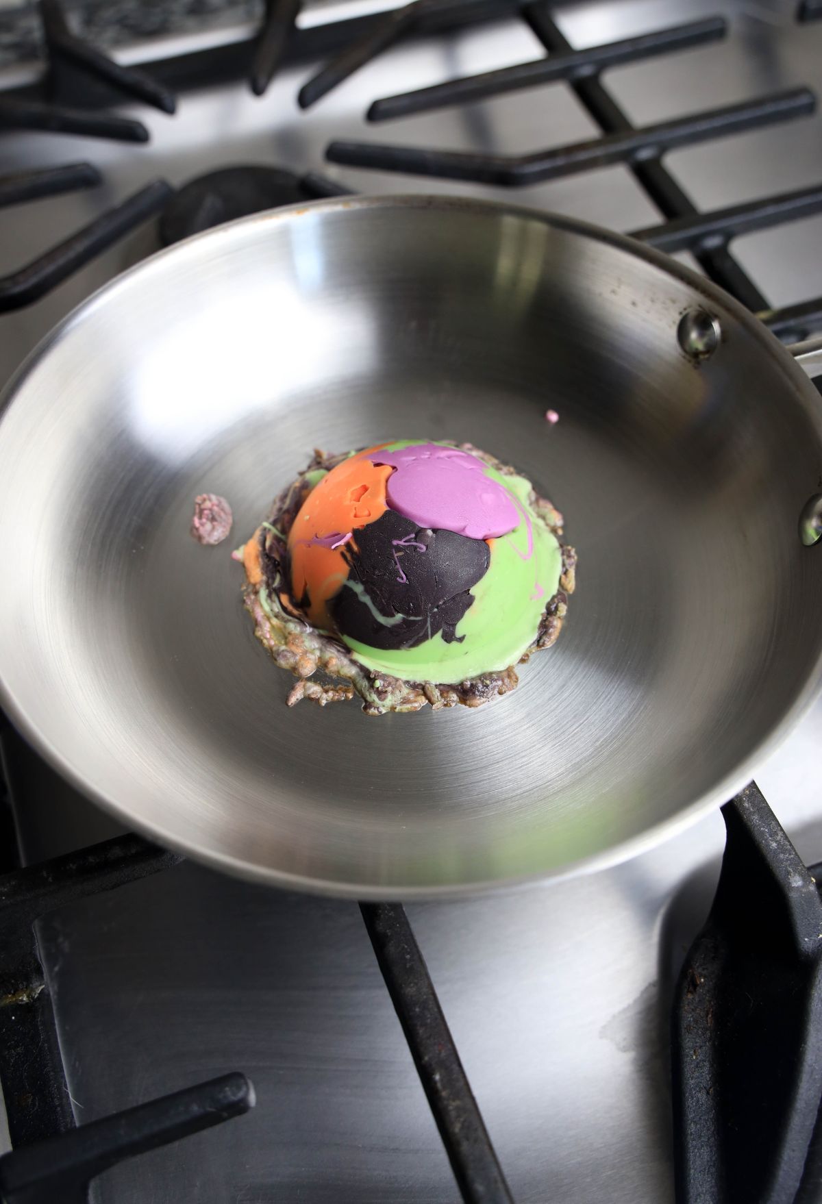 A frying pan with a colorful egg in it.