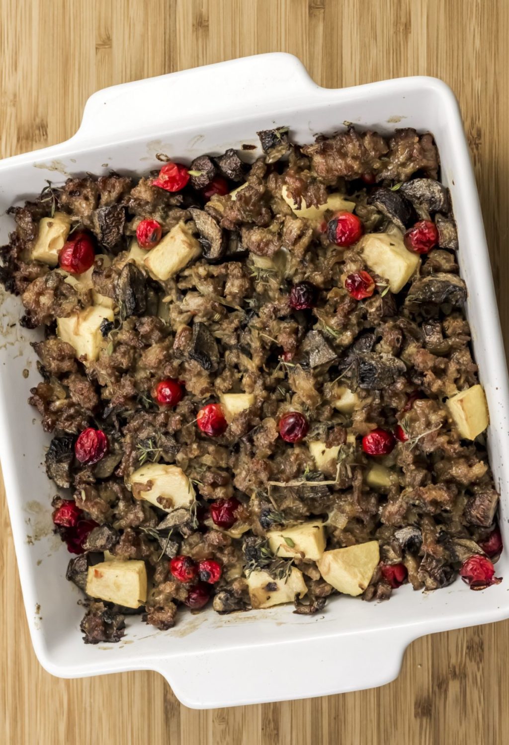 A casserole dish filled with mushrooms and cranberries.