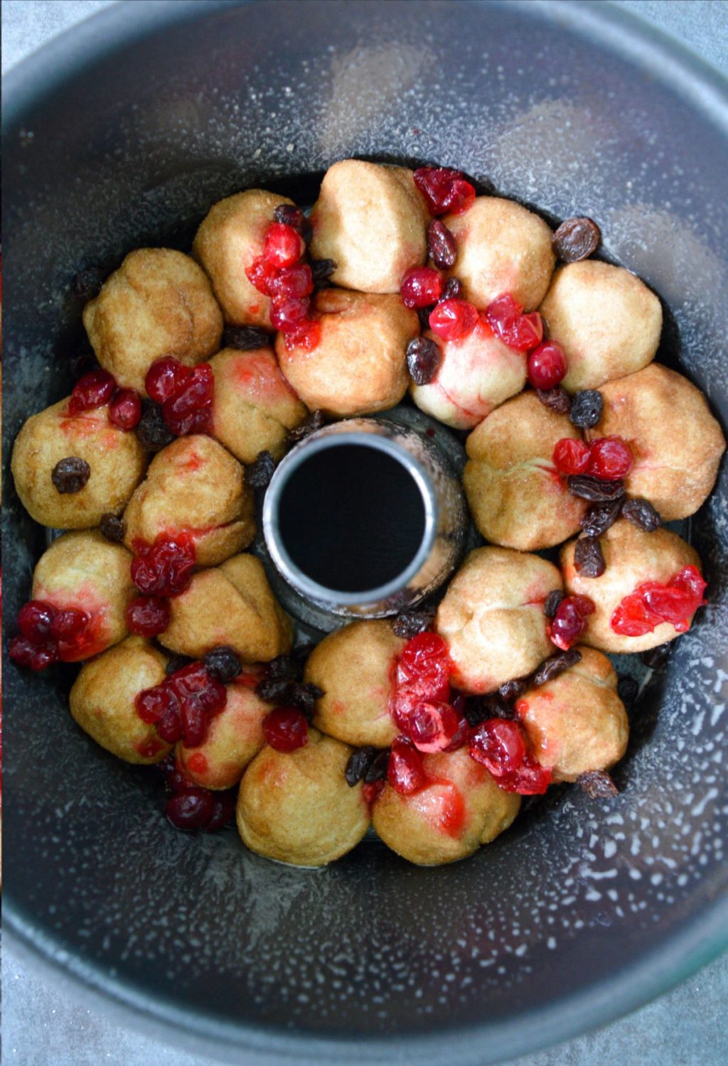 A bowl of doughnuts with cranberries in it.