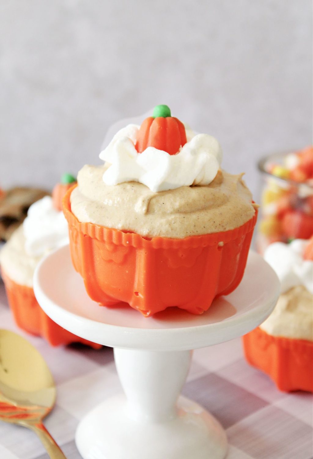 Pumpkin cupcakes on a plate with whipped cream on top.