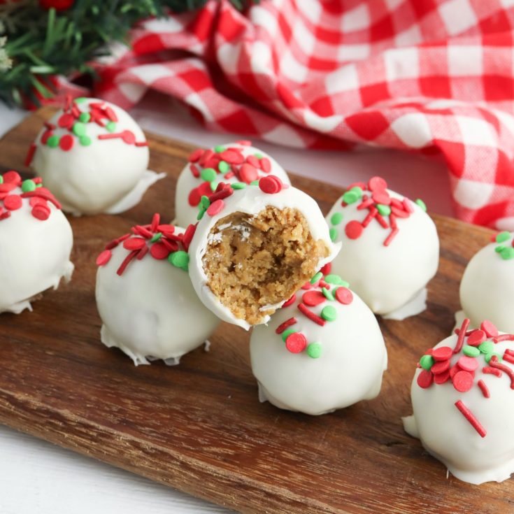 Christmas cookie balls on a wooden cutting board.
