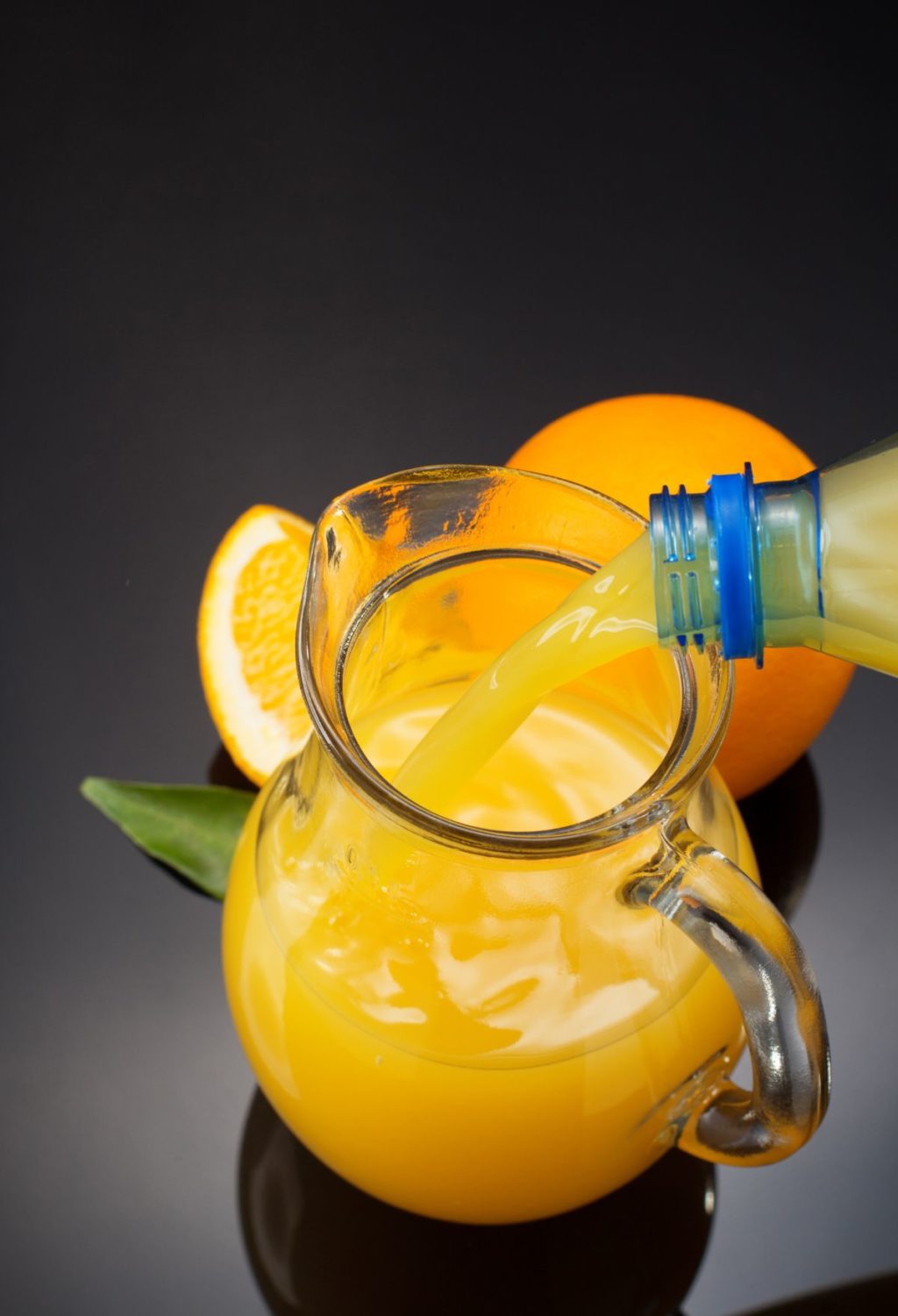 Orange juice being poured into a pitcher.