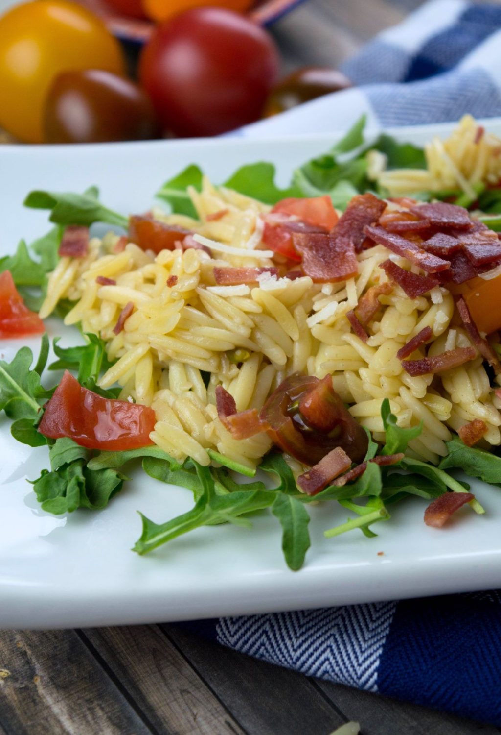 A plate of pasta with tomatoes and bacon.