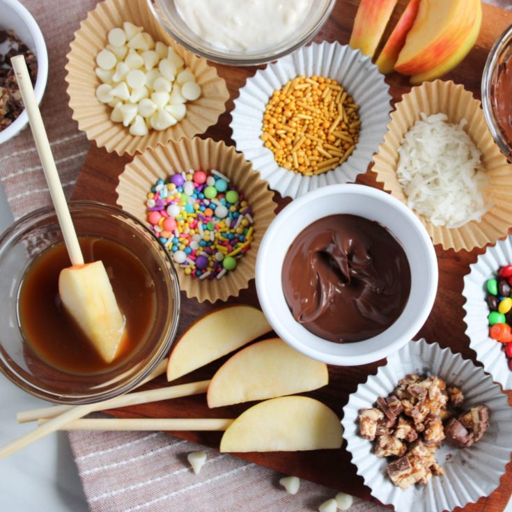 A cutting board with a variety of desserts and toppings.