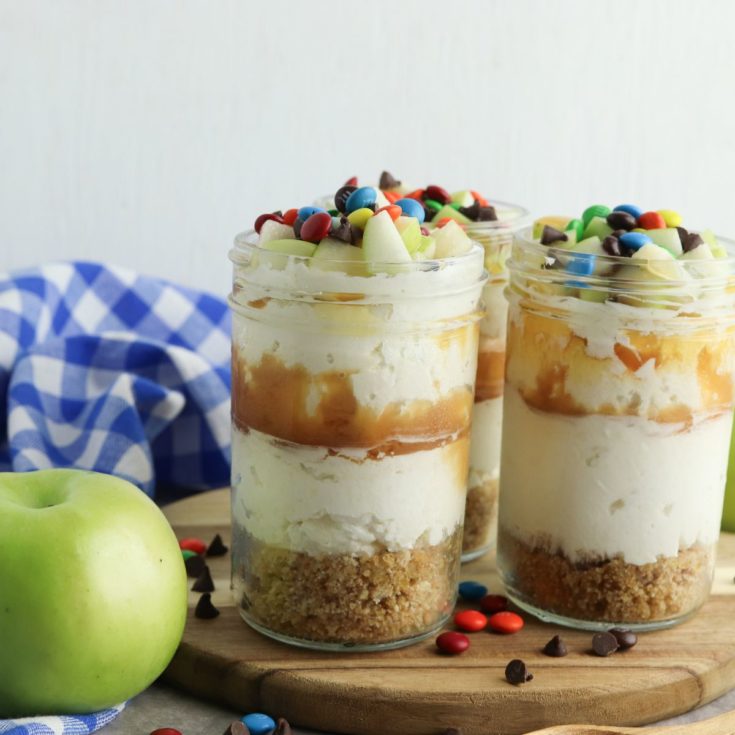 Three mason jars filled with cheesecake and apples.