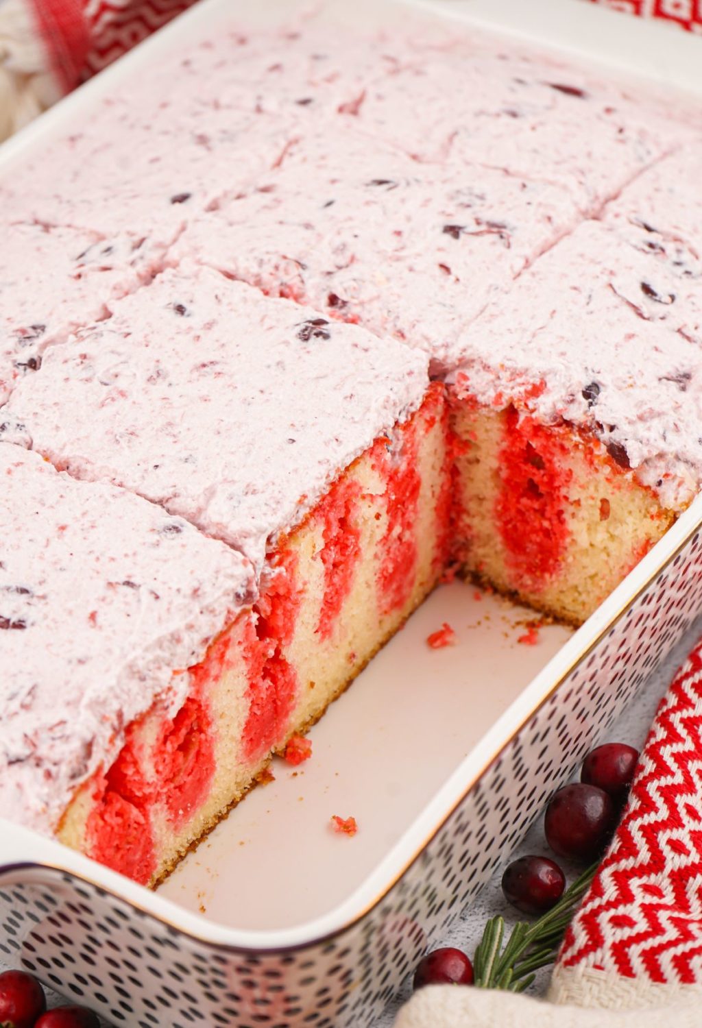 A red and white cake with cranberries on top.