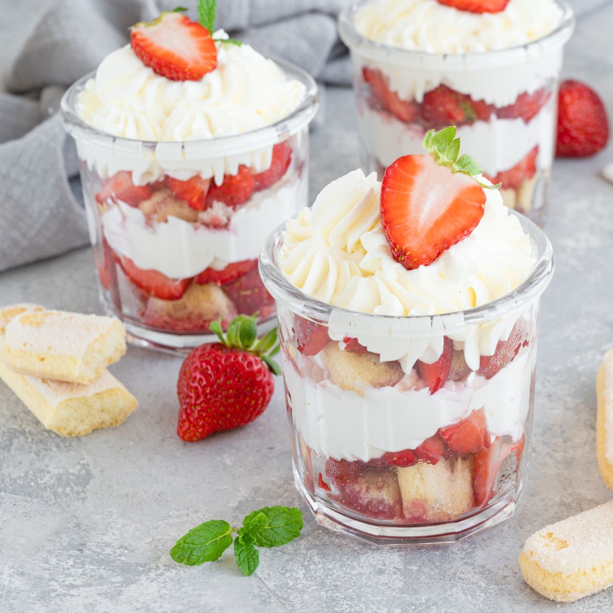 Strawberry trifle in glasses with whipped cream and mint. 
Keywords: strawberry dessert, trifle recipe