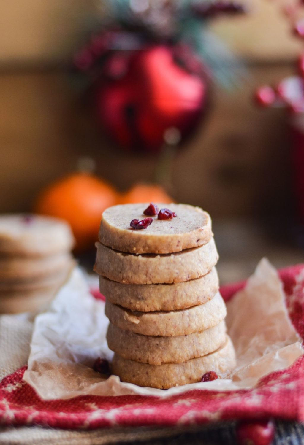 A stack of cookies with cranberries on a napkin.