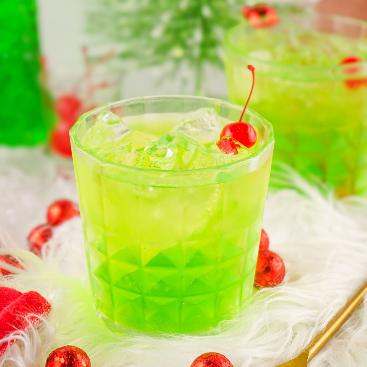 A green drink with a cherry on top.