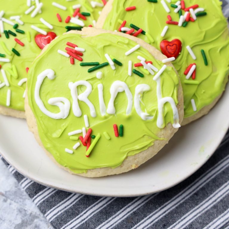 Grinch cookies with sprinkles and icing on a plate.