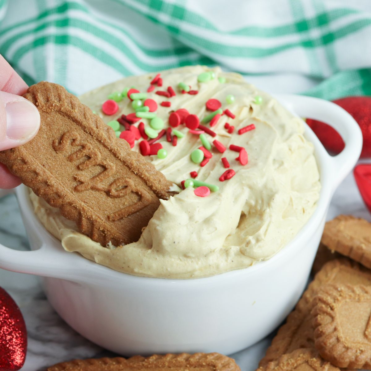 A person holding a bowl of gingerbread cookie dip.