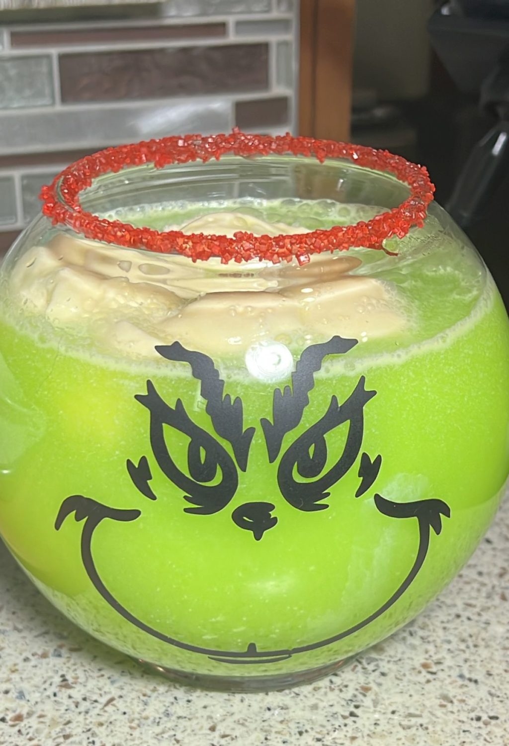 A bowl of green drink with a grin on it.