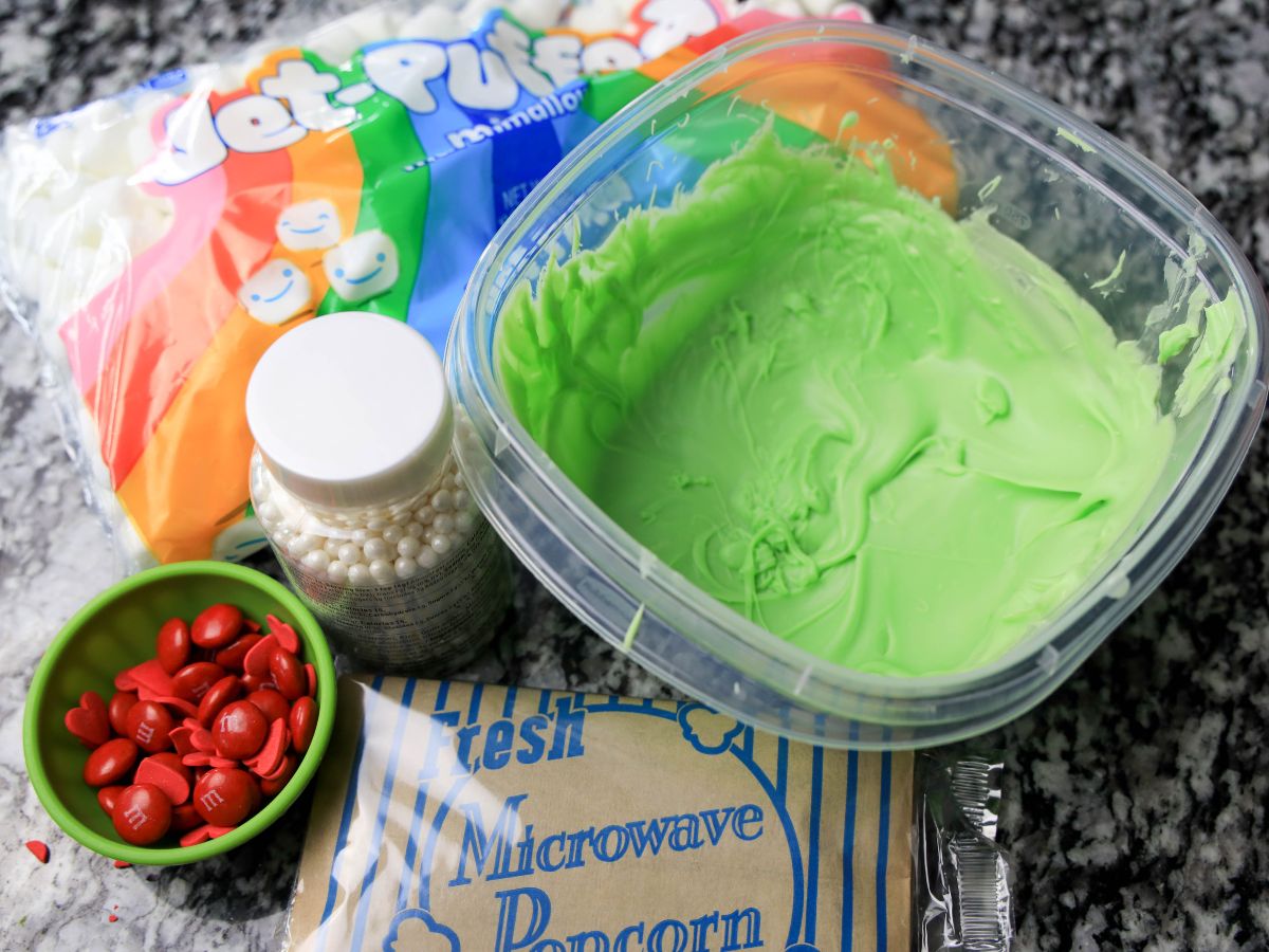 A bowl of green icing and other ingredients.