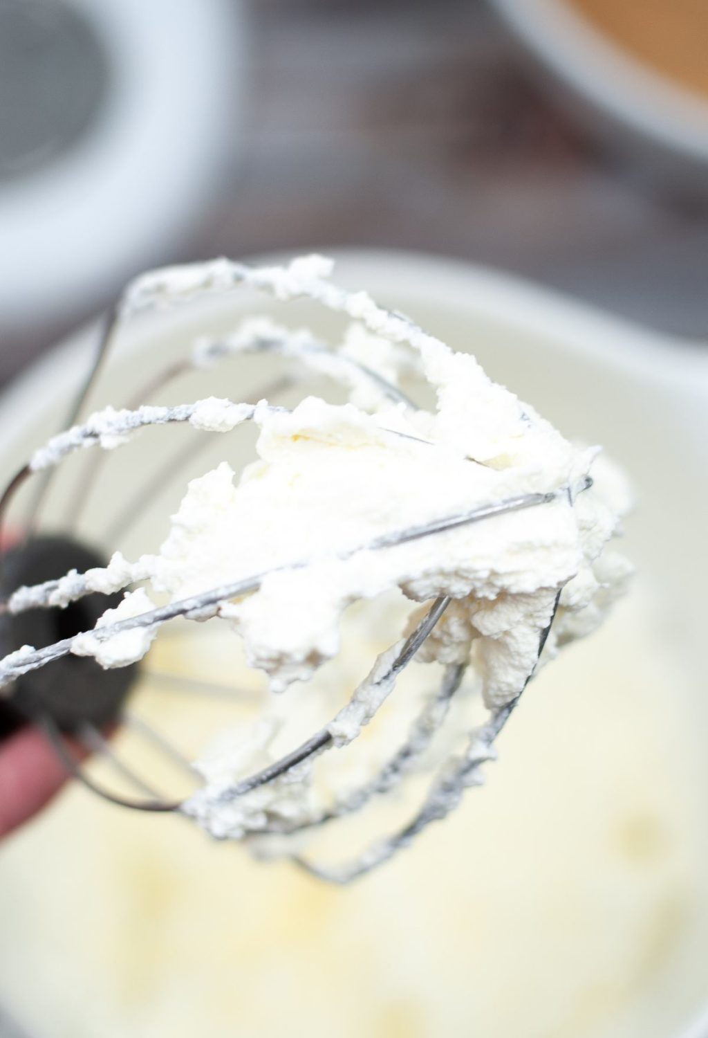 Whipping cream with a whisk in a bowl.