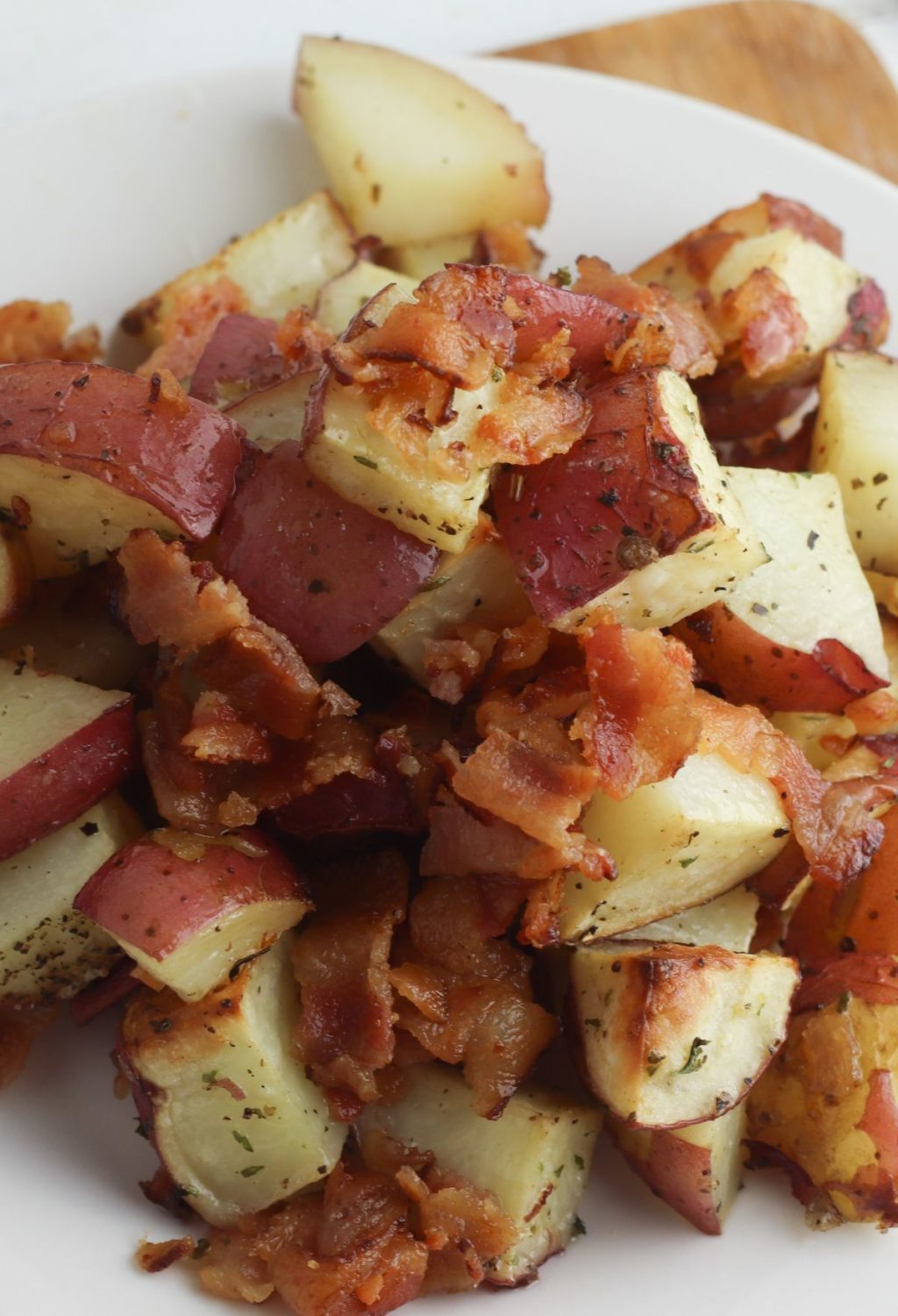Potatoes with bacon and herbs on a plate.