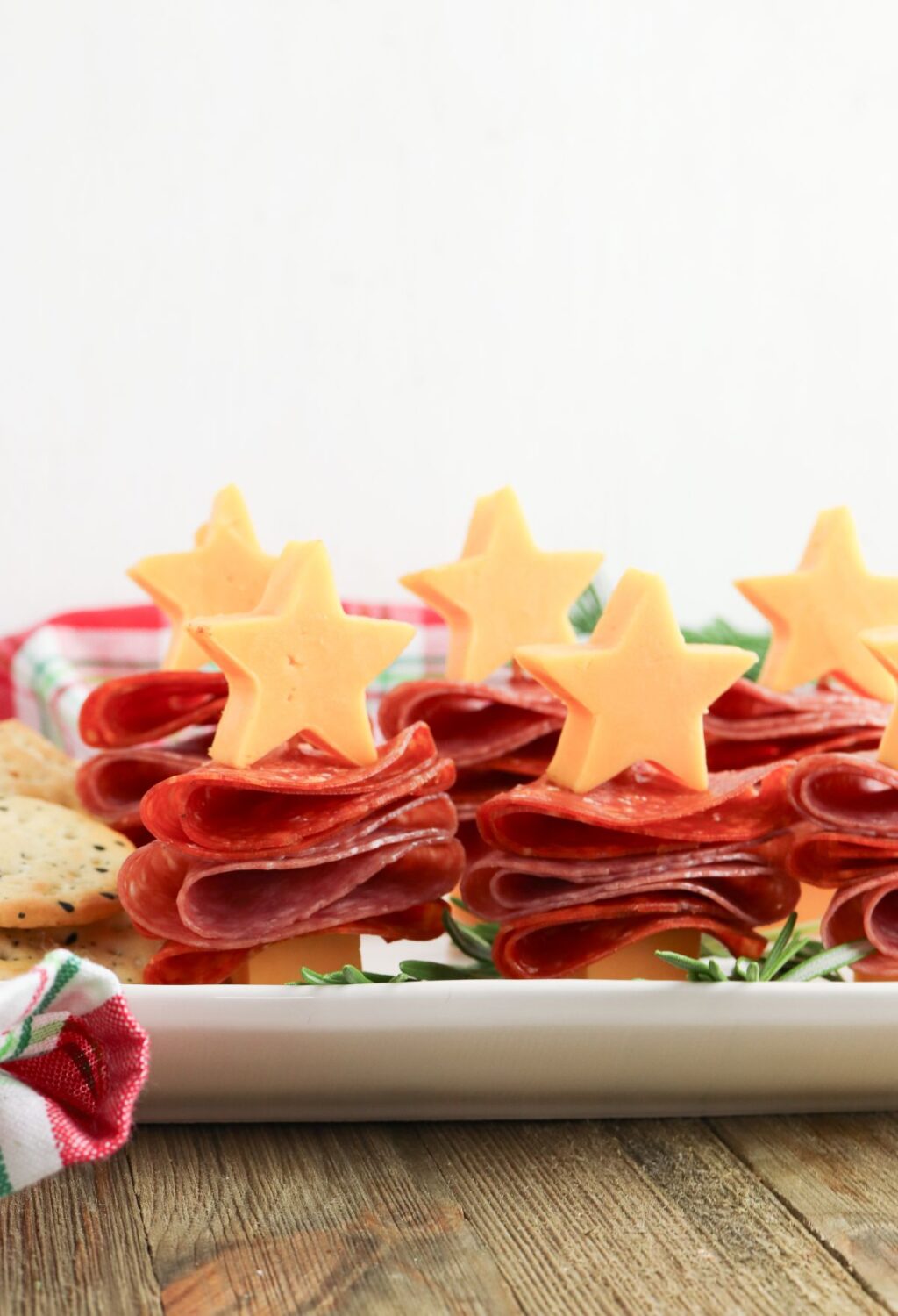 A plate with cheese and crackers in the shape of a christmas tree.