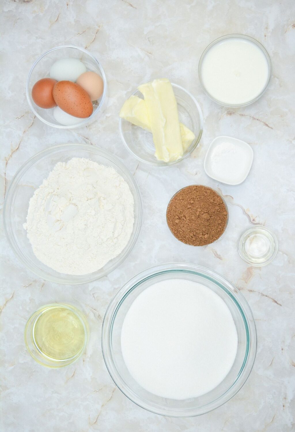 The ingredients for a cake including eggs, flour, sugar and butter.