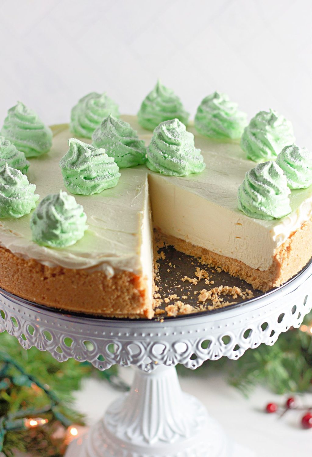 A green cheesecake with a slice taken out.