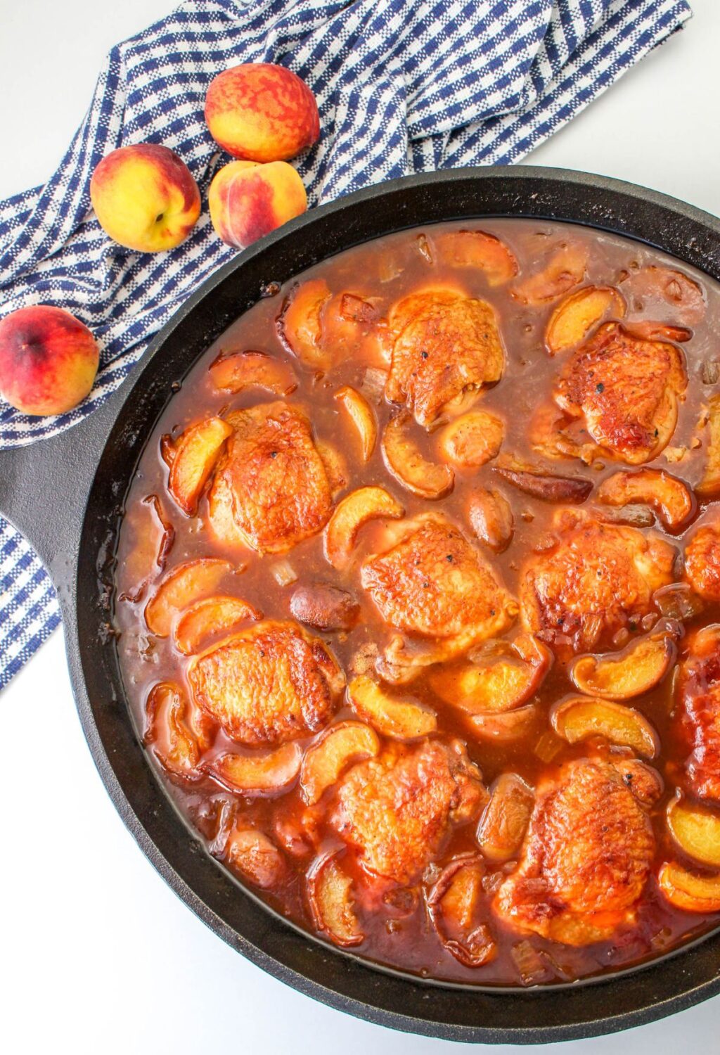 Peach chicken in a skillet with peaches.