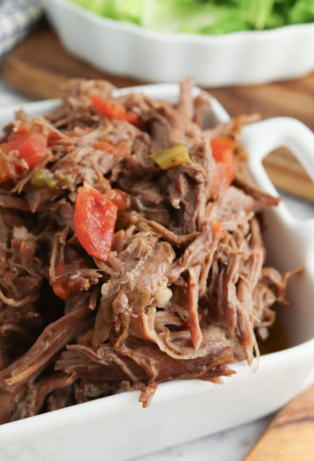 A white dish filled with shredded beef and vegetables.