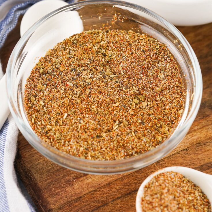 A bowl of seasoning with a spoon next to it.
