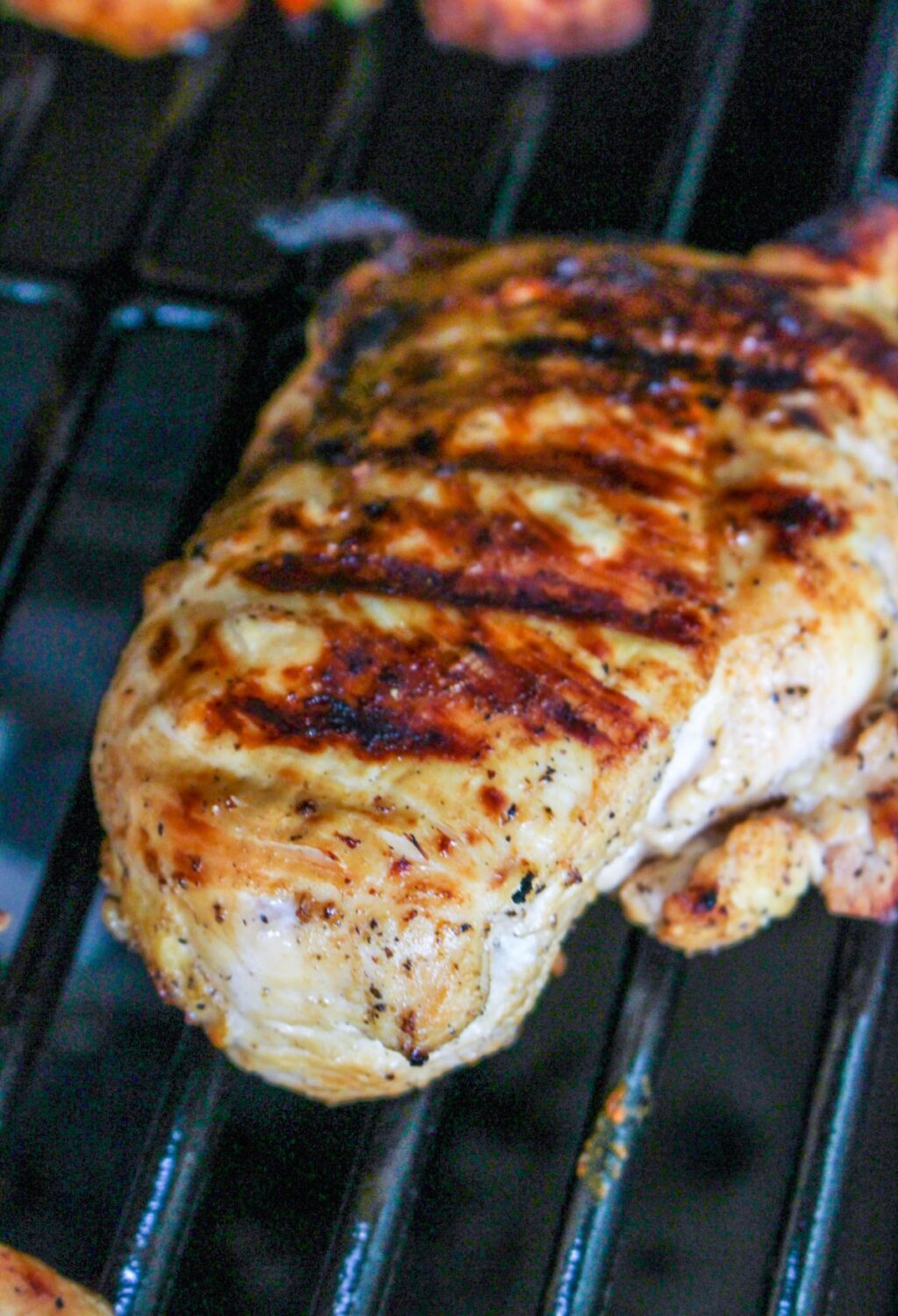 A piece of chicken is being cooked on a grill.