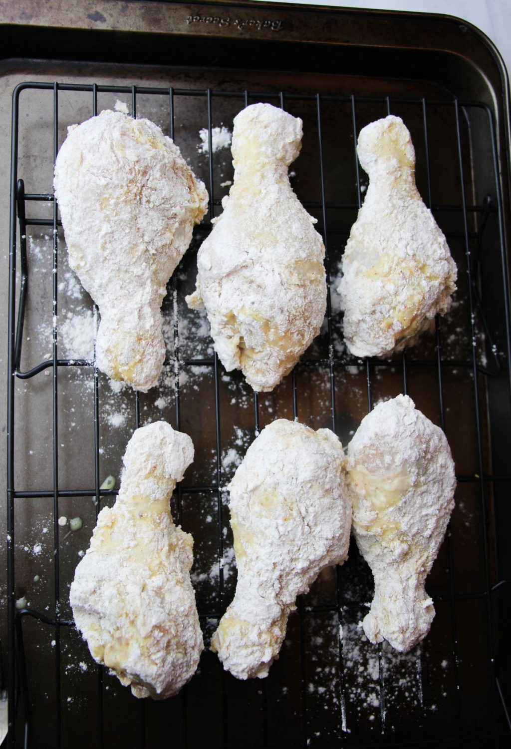 Powdered chicken wings on a baking sheet.