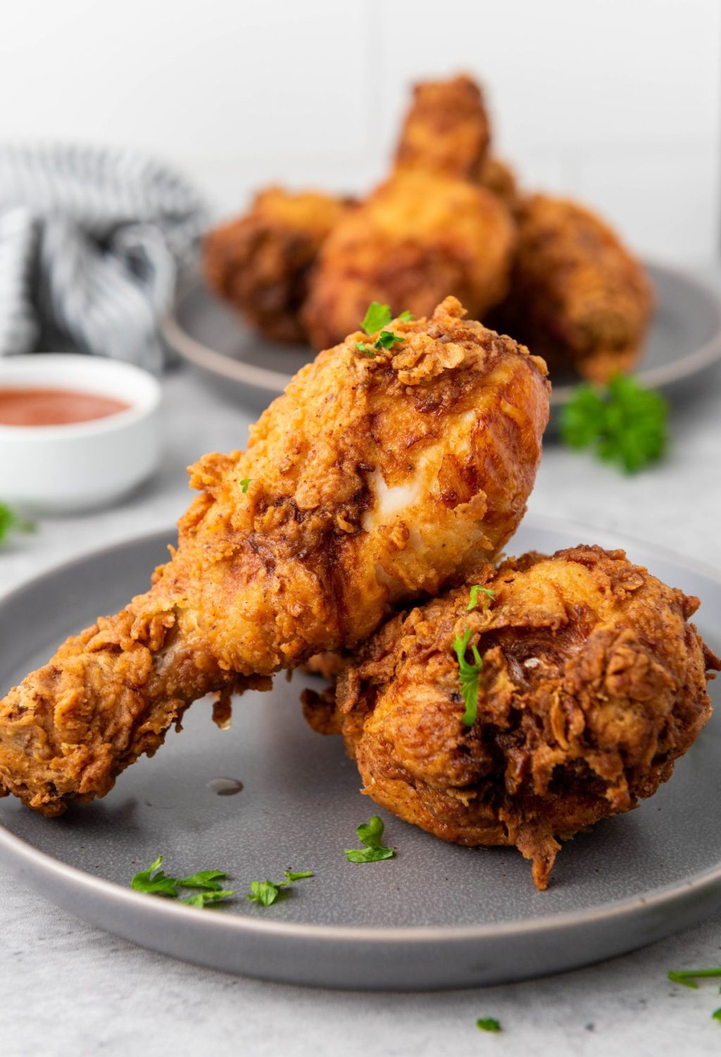 Fried chicken on a plate with sauce on the side.