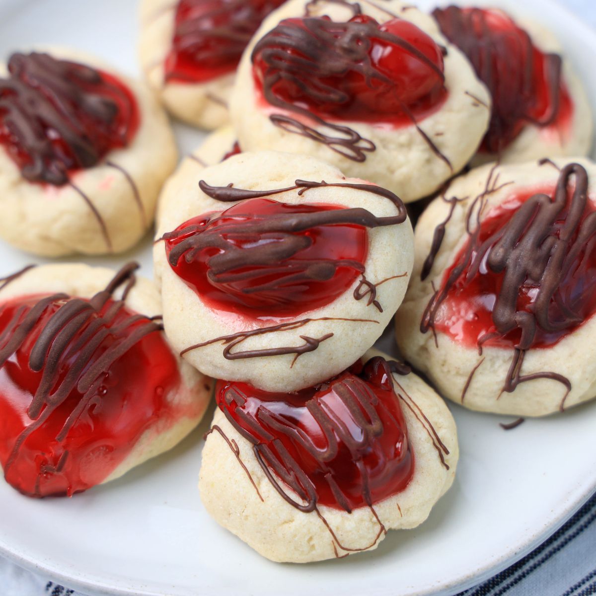 A plate of cookies covered in chocolate and cherry sauce.