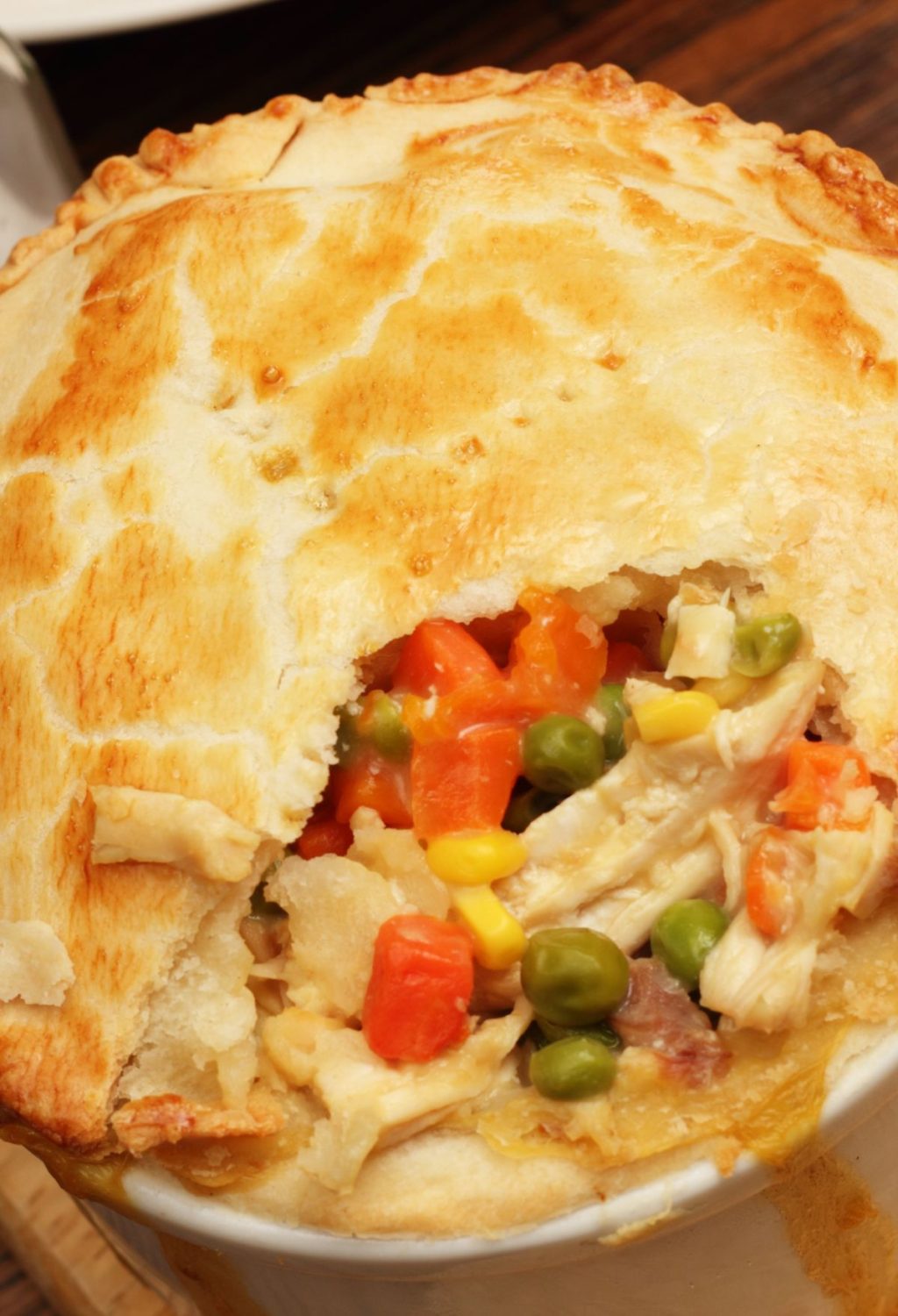 A chicken pot pie is sitting on a wooden table.