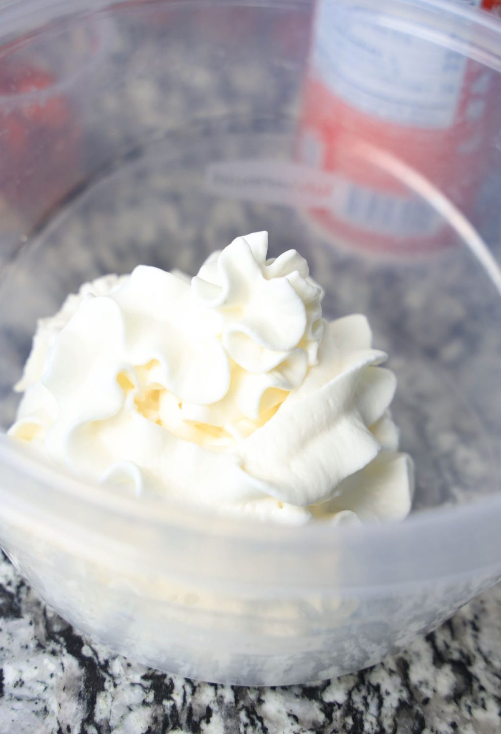 Whipped cream in a bowl on a counter.