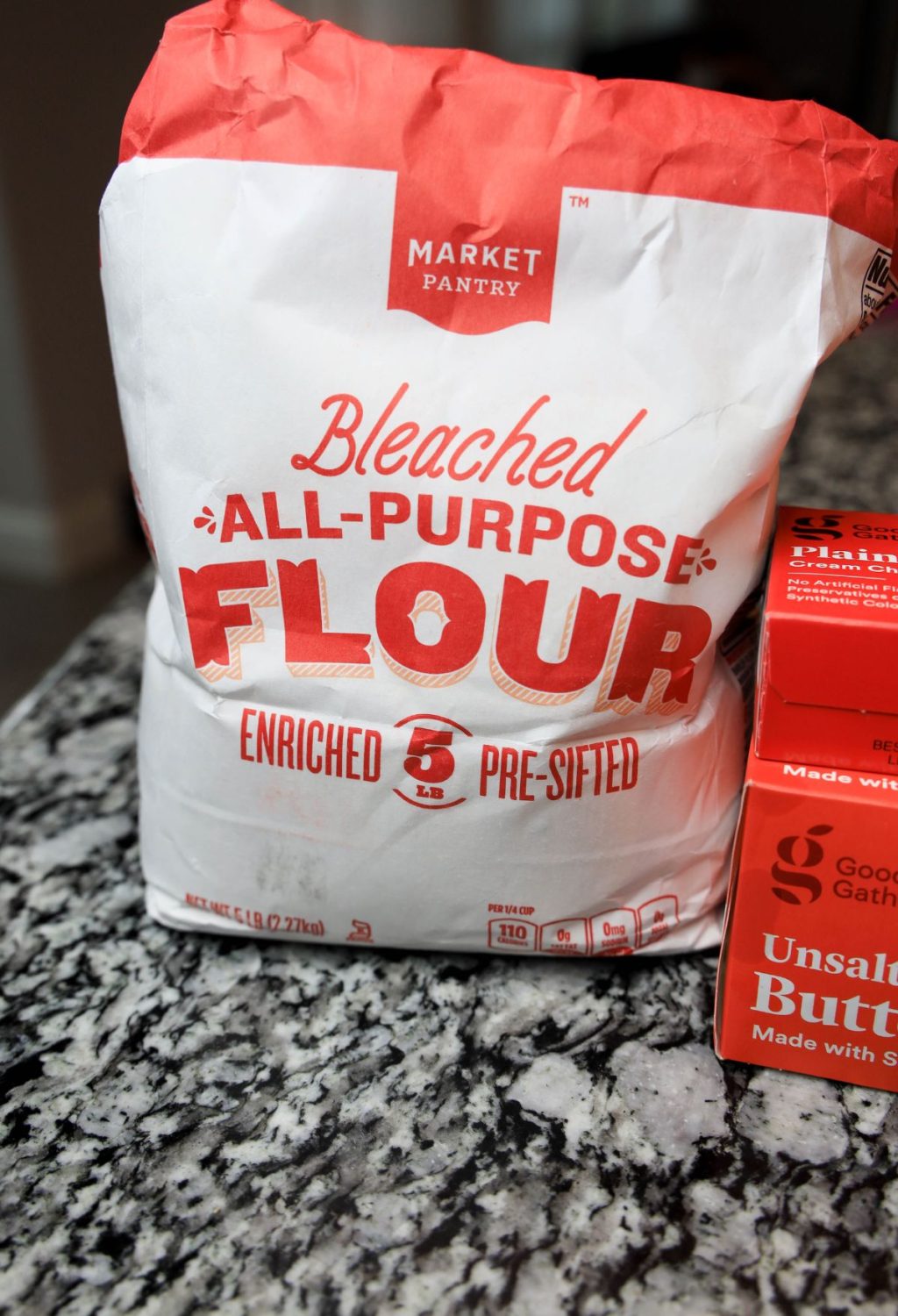 A bag of all purpose flour next to a bag of flour.