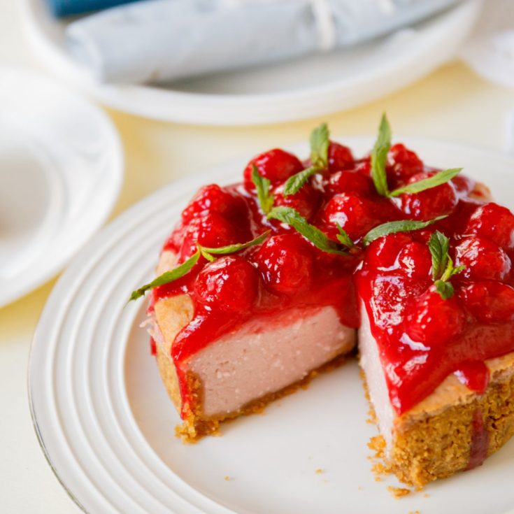A slice of cherry cheesecake on a plate.