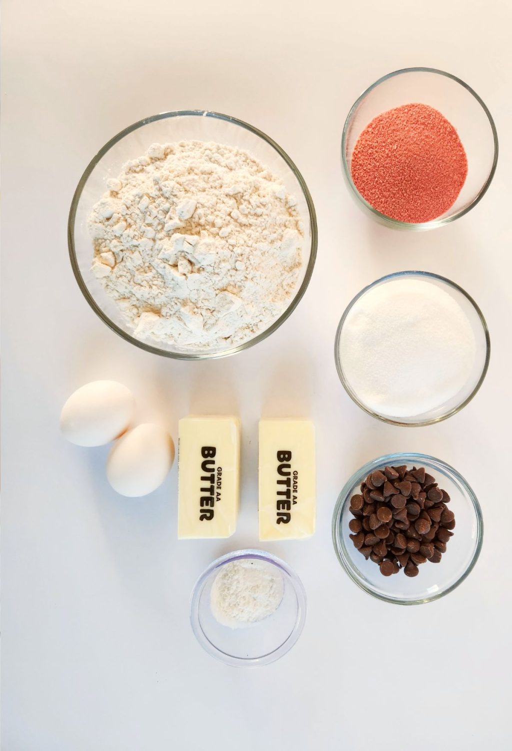 The ingredients for a chocolate cake are laid out on a white surface.