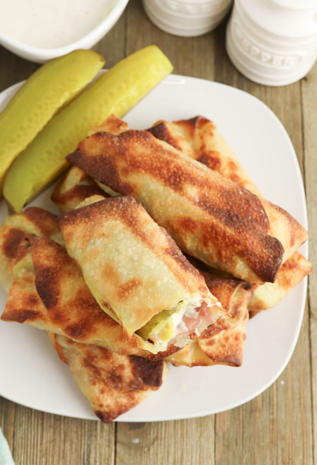 Ham and cheese quesadillas on a plate with pickles.
