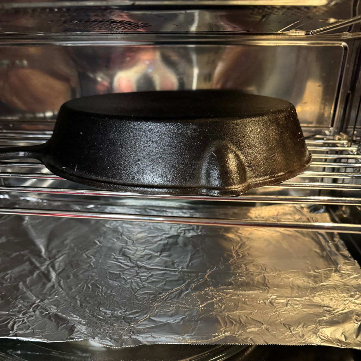 A black cast iron skillet sitting in an oven.