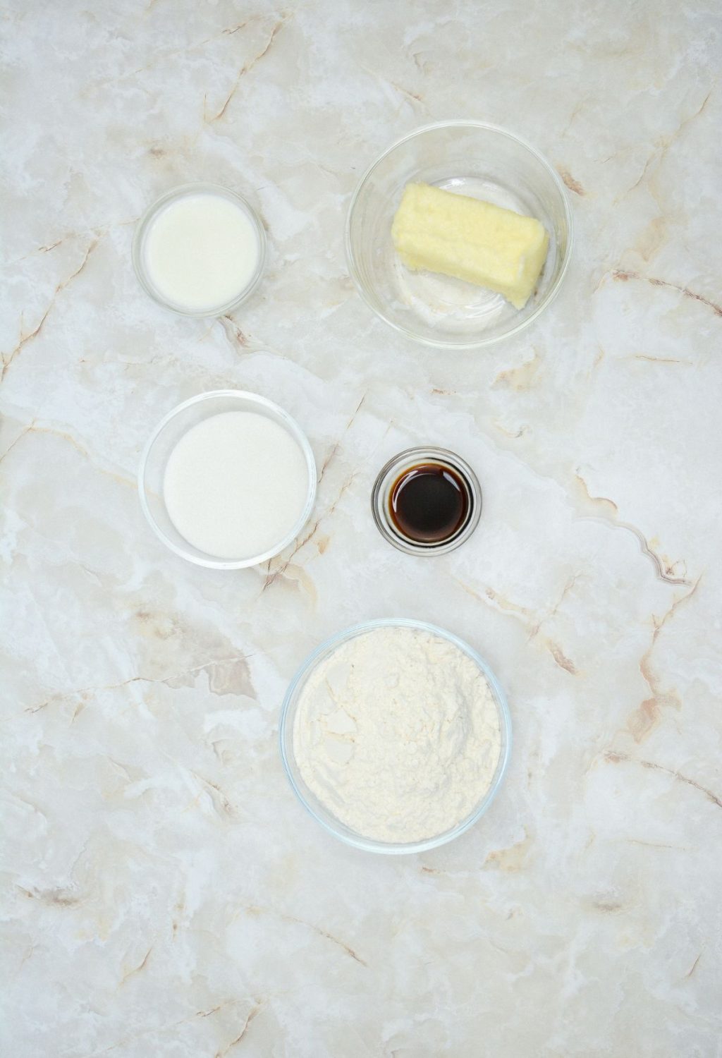 The ingredients for a cake are shown on a marble table.