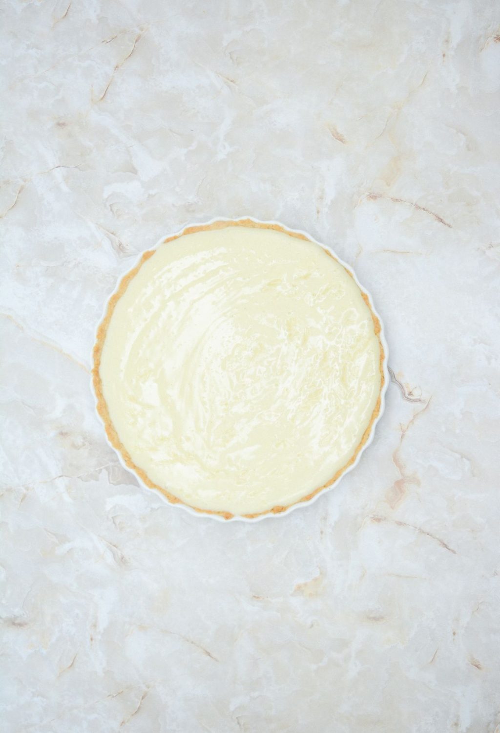 An image of a lemon tart on a marble surface.