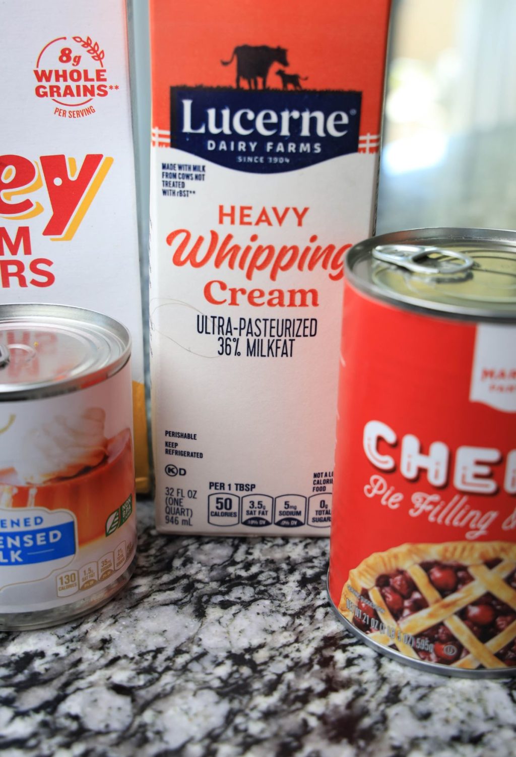 A can of cream cheese, a can of whipping cream, and a can of whipping cream.