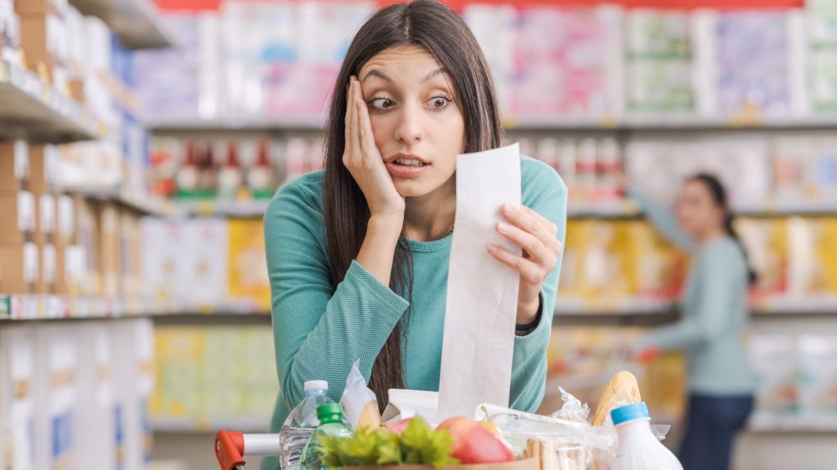woman in shock with receipt at supermarket grocery store