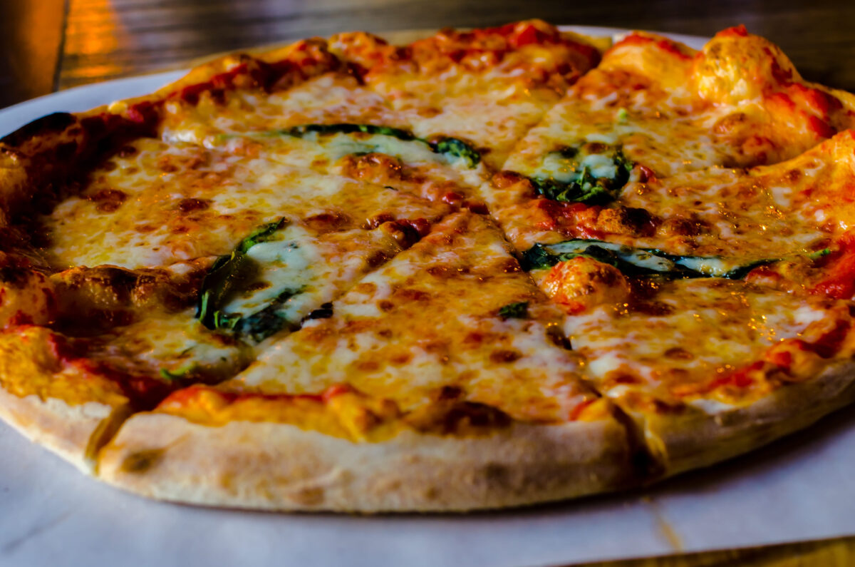 The Most Expensive Pizzas in America 3 Margarita pizza on a restaurant table with basil. Closeup of pizza with cheese