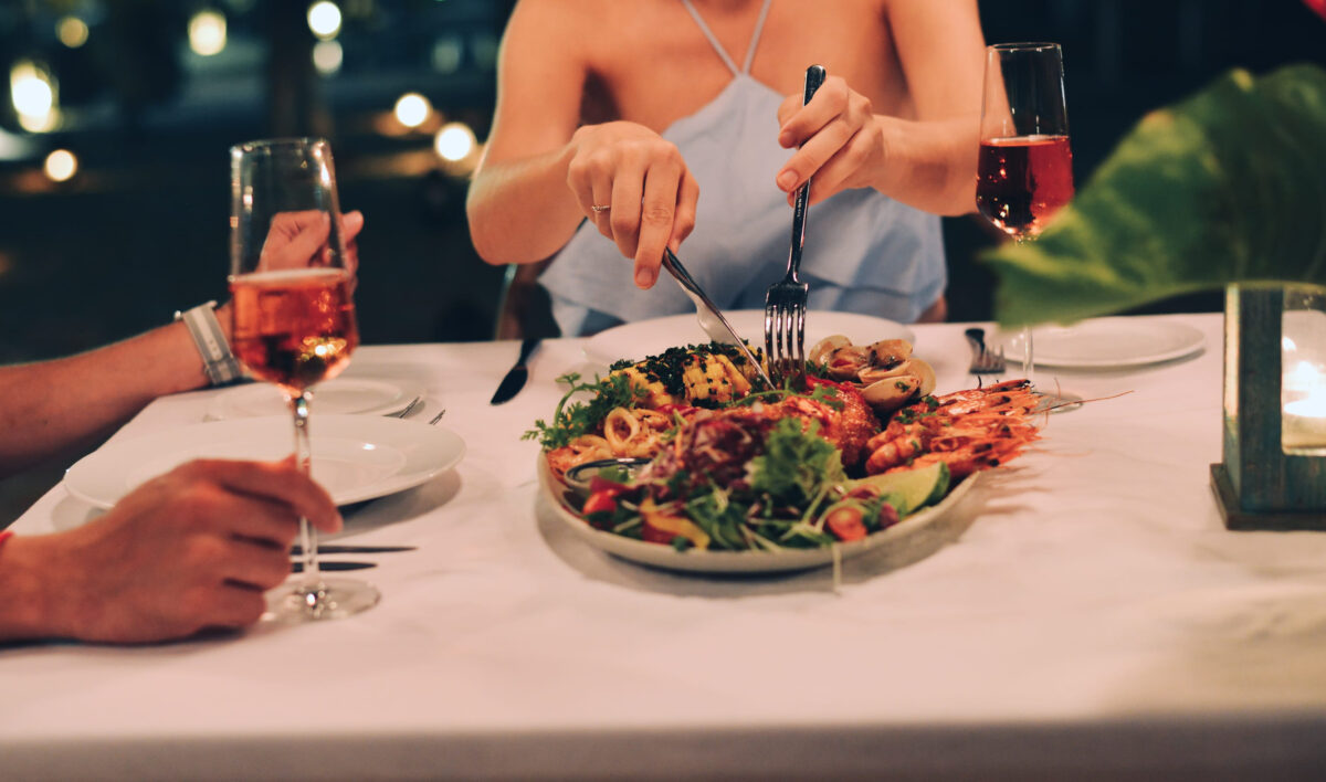 10 The Worst Foods to Eat on a Date 4 Young woman with a dinner on beach at luxury resort in Phan Thiet, Vietnam.