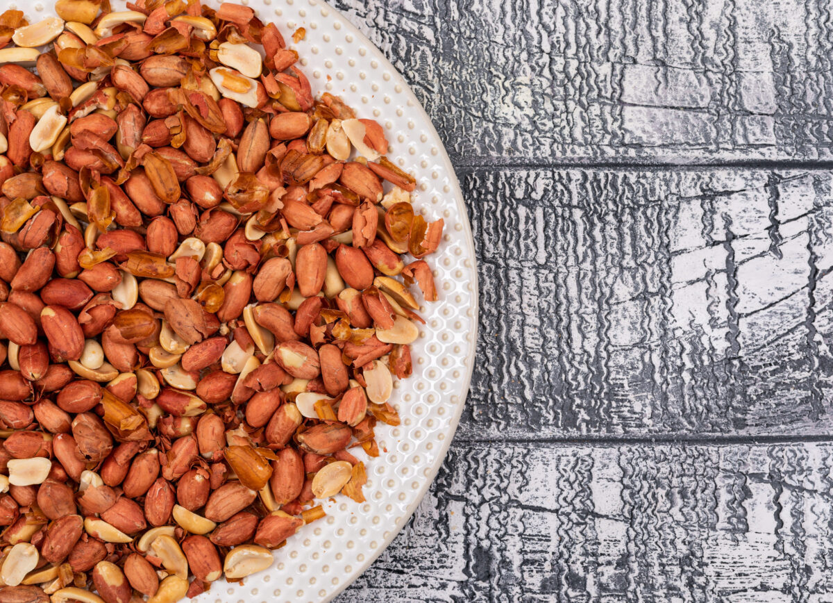 The Secret Ingredient in These 6 Popular Foods That Could Be Triggering Your Allergies 2 Top view peanuts in plate on wooden background with copy space